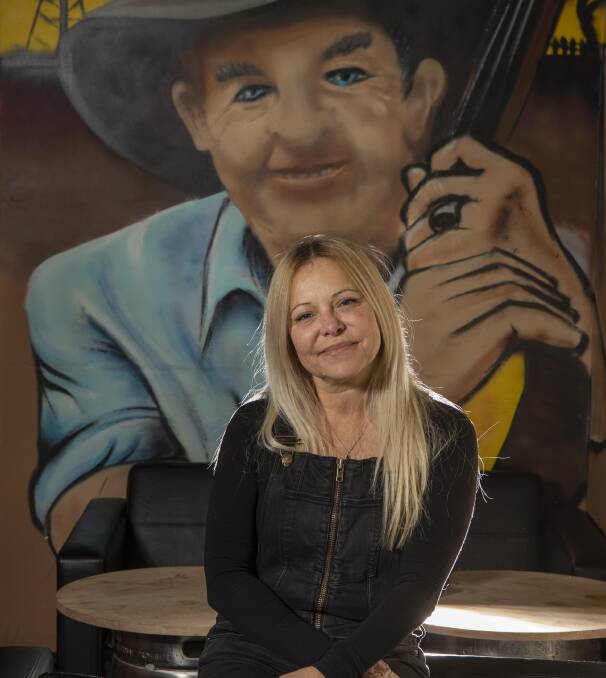 Helen Filips and a mural by a local artist of Slim Dusty.