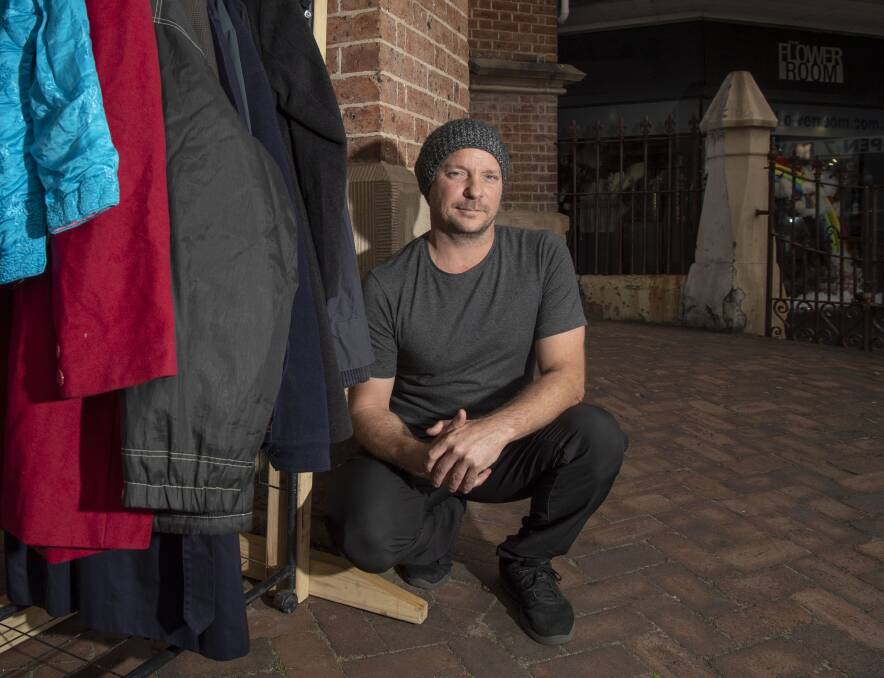 WARMING UP: Rick Everett at his coat rack, which he is hoping the community will help keep replenished for those in need. Picture: Simon Bullard